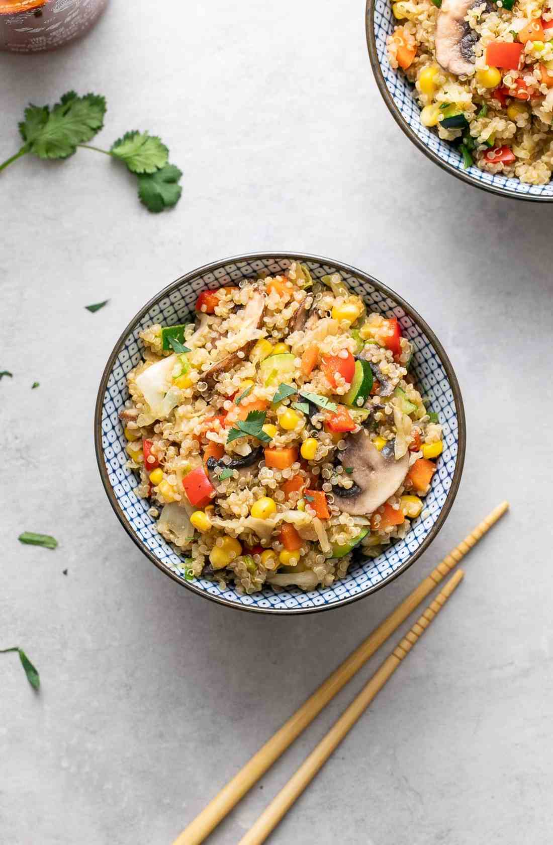 Rainbow quinoa fried rice with colorful veggies, fluffy grains, and a savory soy glaze