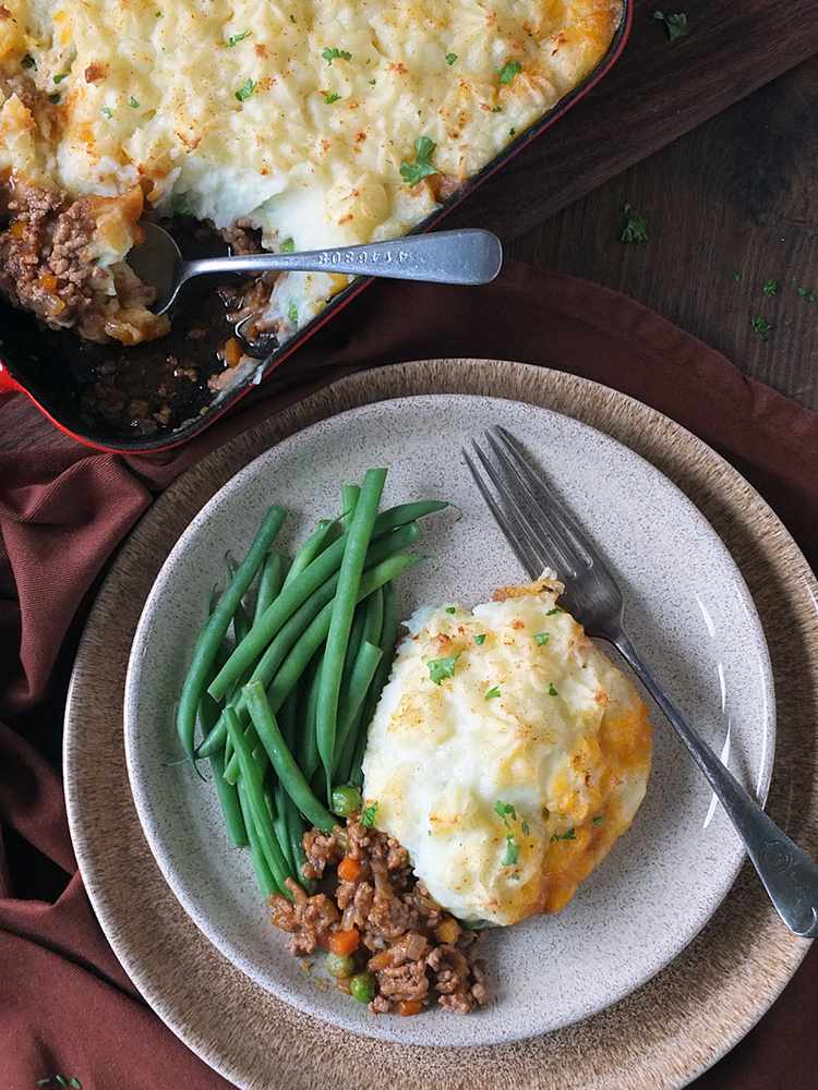 Golden mashed potato topped homestyle shepherd's pie with savory beef filling, bubbling cheese