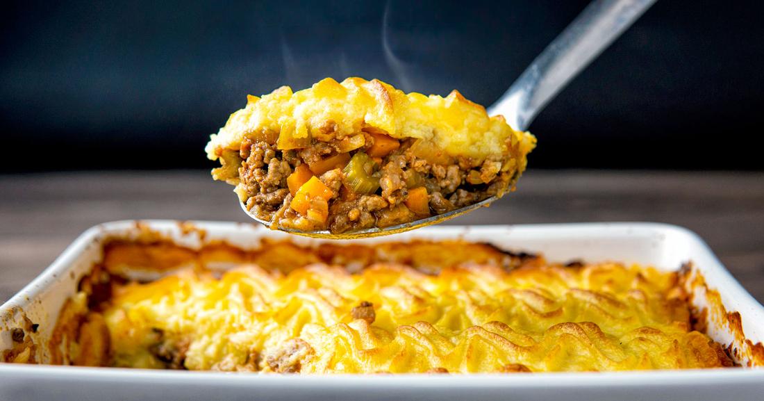Golden mashed potato topped classic lamb shepherd's pie with savory lamb filling, bubbling cheese