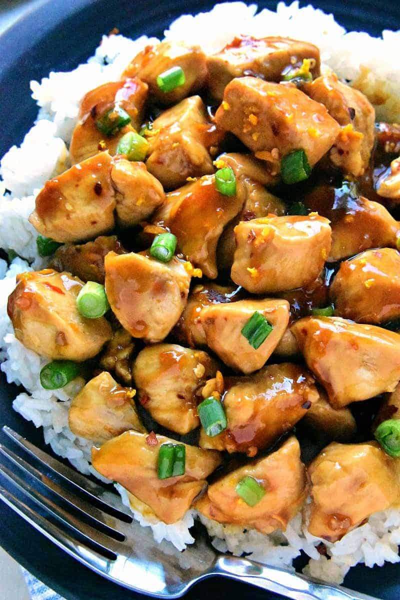 Sautéed chicken pieces coated in a glossy orange glaze, topped with fresh orange slices