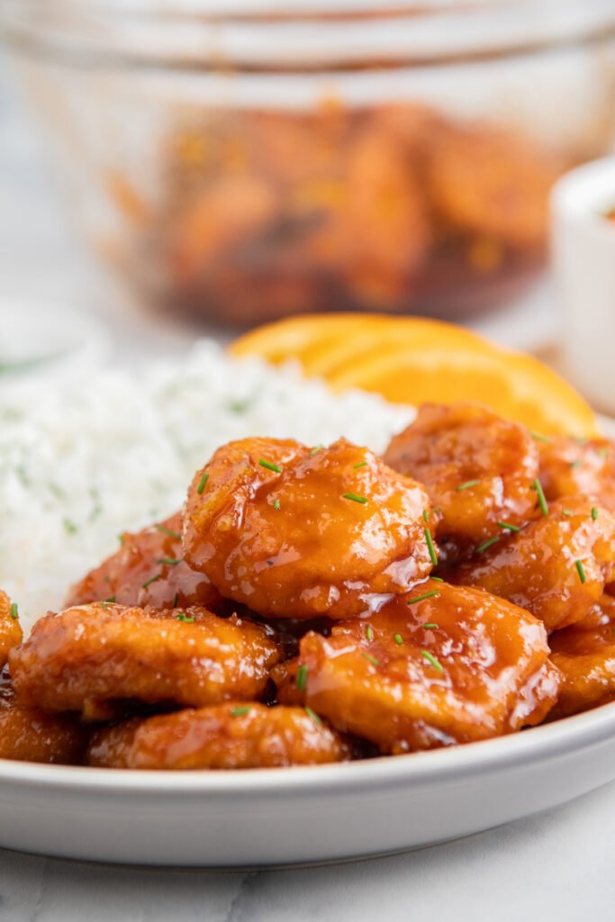 Orange‑glazed skinny chicken served over roasted sweet potato cubes from the air fryer with fresh orange garnish