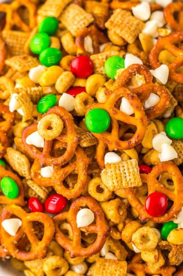 Festive Christmas Chex mix with red & green candy coating, pretzels, and chocolate drizzle