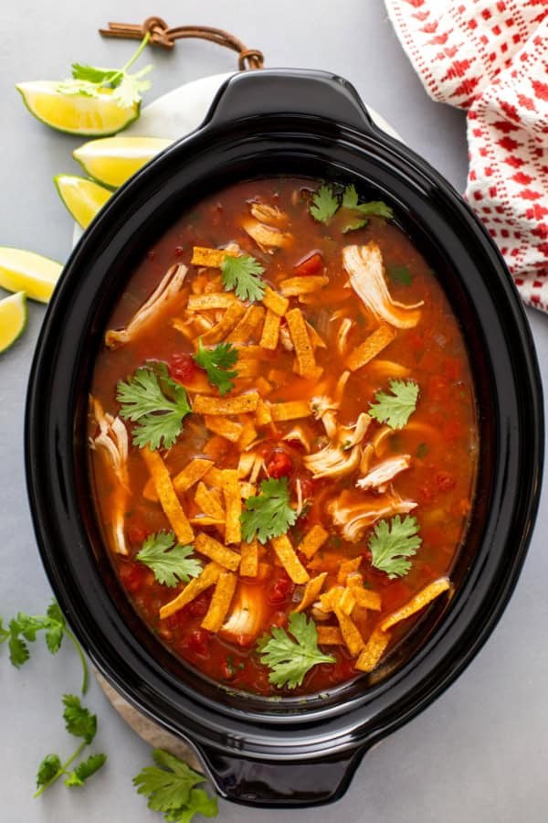 Classic chicken tortilla soup, creamy tomato broth, shredded chicken, crunchy tortilla strips, avocado, lime