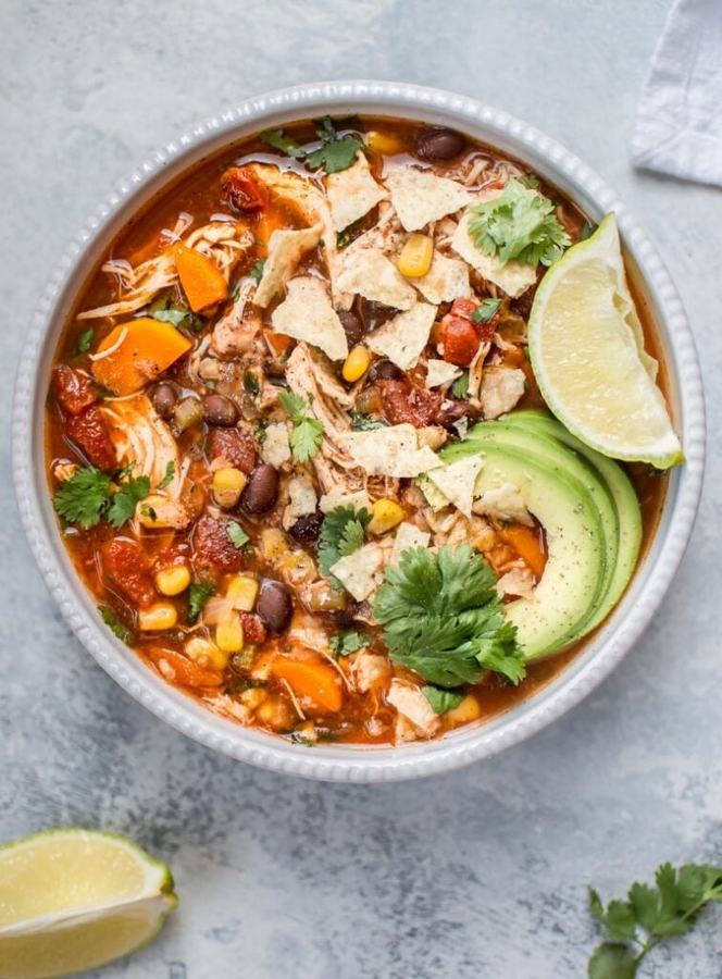 Classic chicken tortilla soup with rich tomato broth, shredded chicken, crispy tortilla strips, avocado, lime