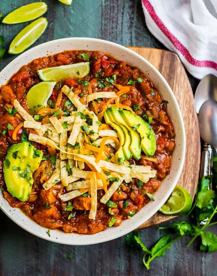 Southwest chicken tortilla soup with smoky tomato broth, shredded chicken, crunchy strips, avocado, lime