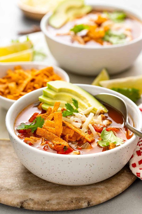 Hearty chicken tortilla soup, black beans, tomato broth, shredded chicken, crispy tortilla strips, cilantro garnish