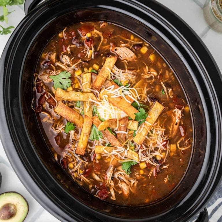 Chicken tortilla soup, corn‑infused tomato broth, shredded chicken, crisp tortilla strips, cilantro, lime