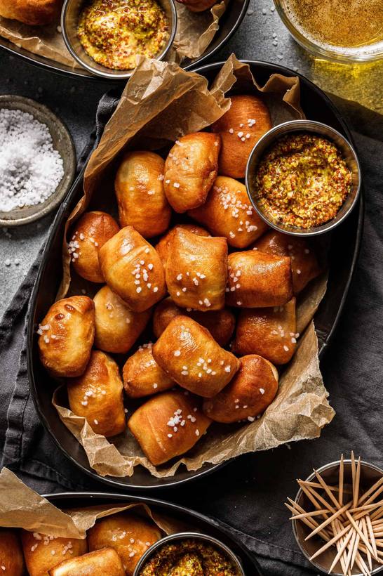 Golden soft pretzel bites cooked in an air fryer, served with a creamy dip