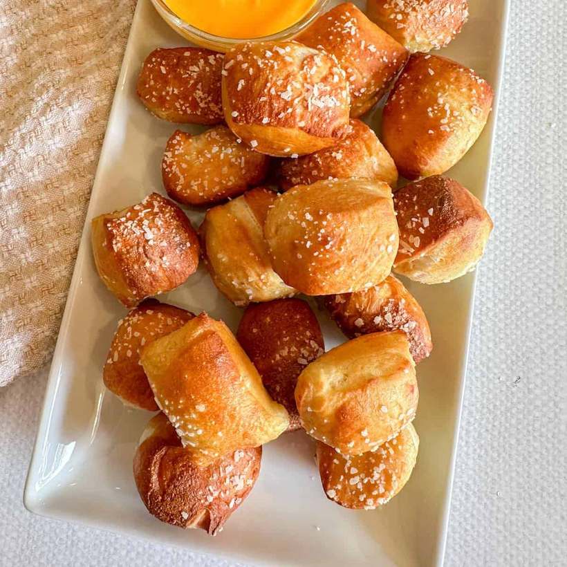 Golden soft pretzel bites cooked in an air fryer, served with a creamy dip