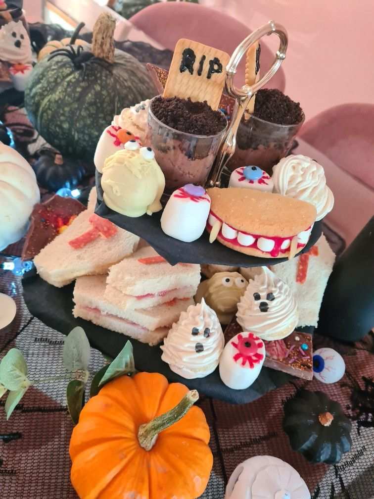 Tiered stand with purple and orange macarons and small tarts