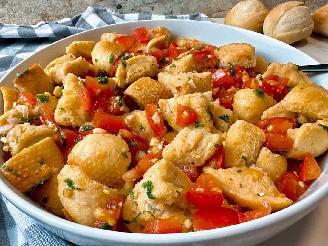 Classic summer panzanella with crusty bread cubes, ripe tomatoes, basil, mozzarella, olive oil