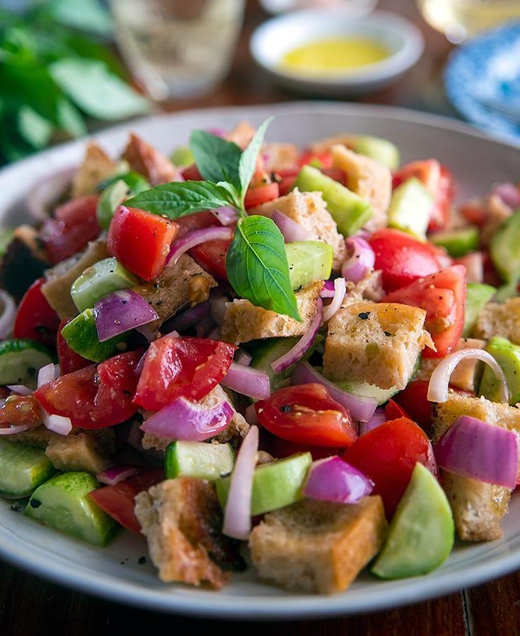 Classic Tuscan panzanella with crusty bread cubes, ripe tomatoes, basil, mozzarella, olive oil