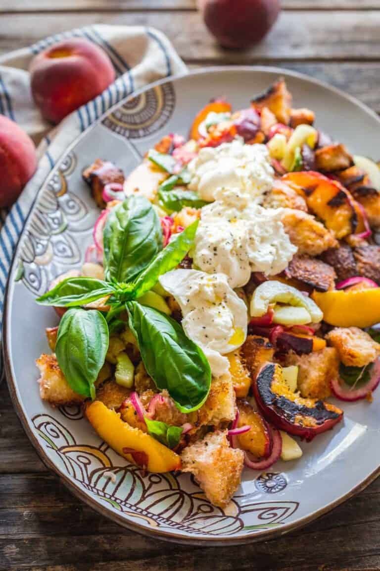 Peach & mozzarella panzanella with toasted Tuscan bread, juicy tomatoes, basil, and creamy mozzarella in a bright vinaigrette