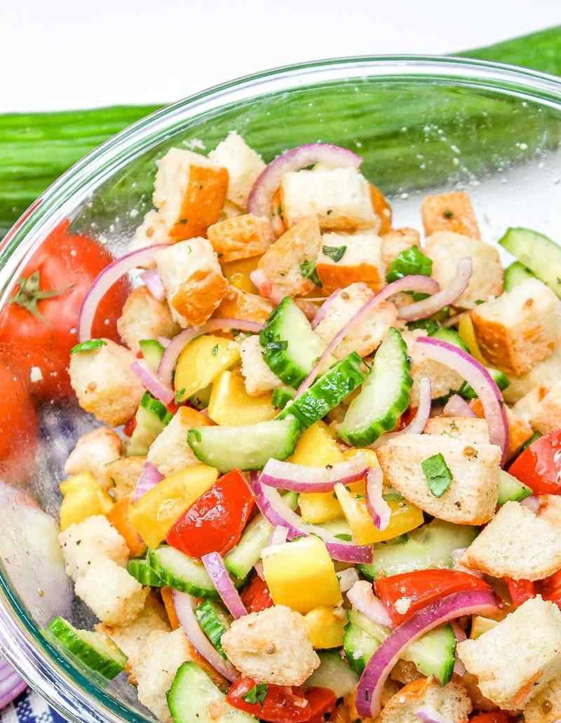 Classic summer panzanella with crusty bread cubes, ripe tomatoes, basil, mozzarella, and olive oil