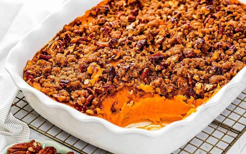 Golden brown eggless sweet potato casserole seasoned with cinnamon and nutmeg in ceramic dish