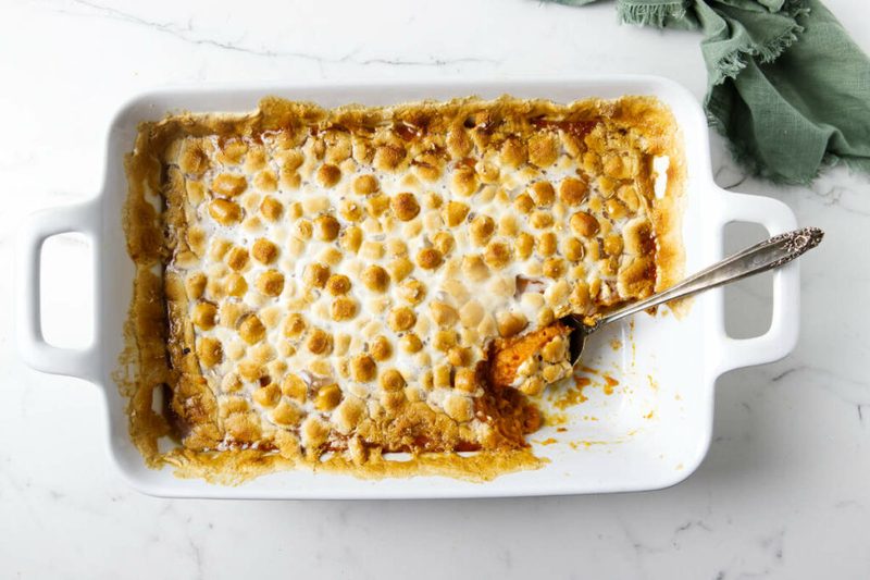 Classic marshmallow-topped sweet potato casserole with half toasted pecans and gooey melted marshmallows