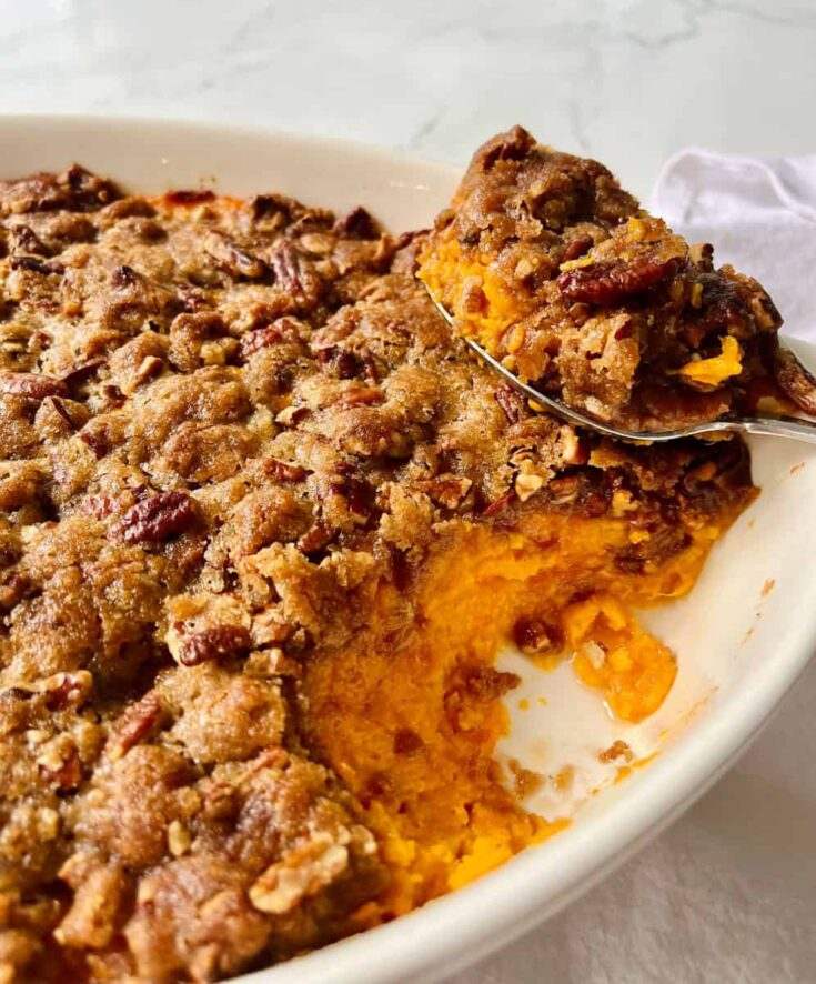 Aromatic classic sweet potato casserole with flecks of crystallized ginger and melted butter