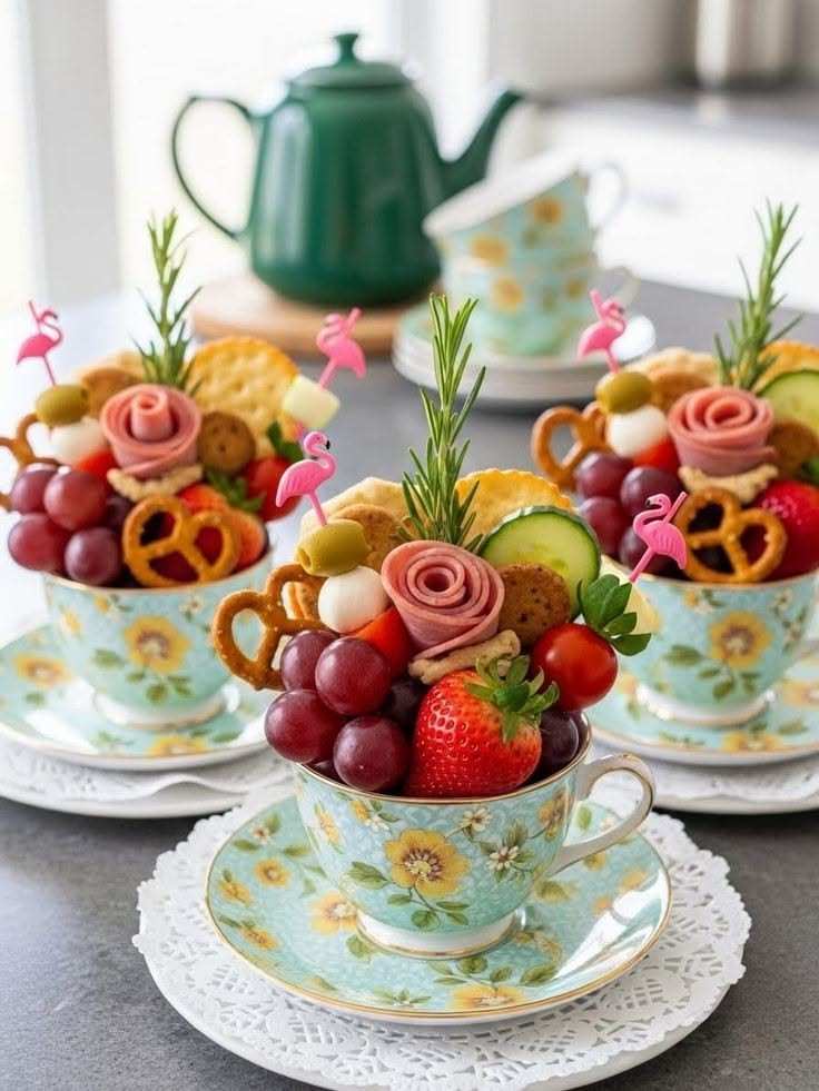 Small teacups filled with mini cheeses, nuts, and dried fruits