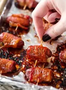 Mini cocktail sausages wrapped in bacon, baked until caramelized and glossy