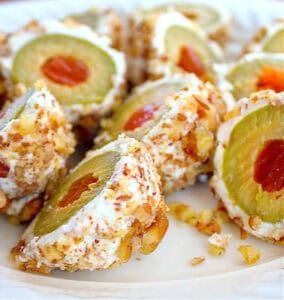 Bite‑size cream cheese rolls stuffed with walnuts and sliced olives on a platter