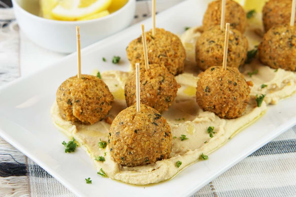 Mini skewers alternating falafel balls and beef meatballs, served with creamy hummus